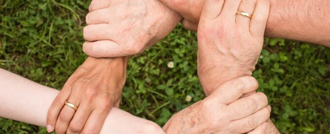 Hände sind ineinander verschlungen und symbolisieren damit teamgeist und einigkeit.